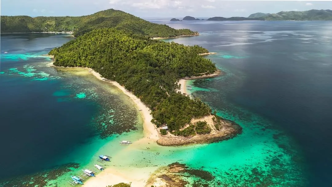 Tropical island ringed by white sand and turquoise water
