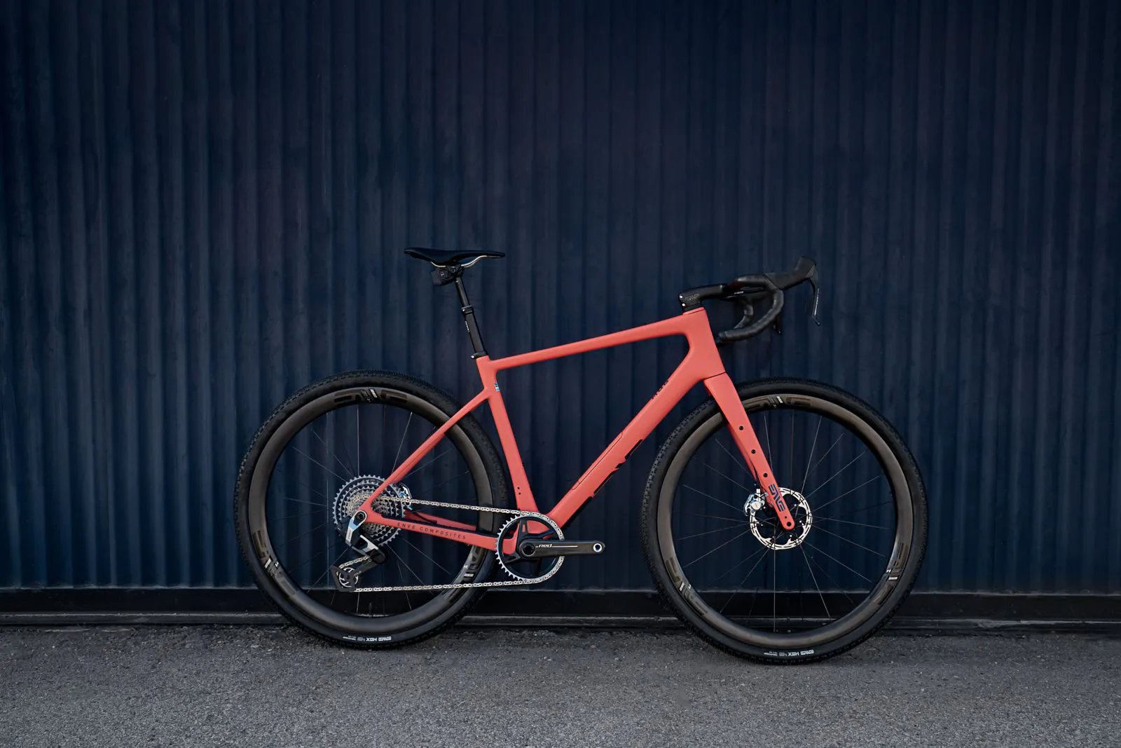 Coral ENVE MOG side-on against a blue corrugated wall